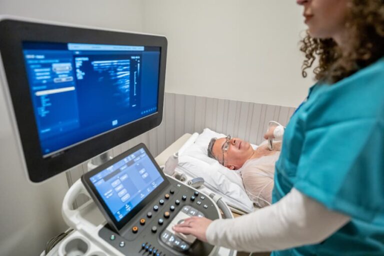 Sonographer doing echocardiogram on patient in office