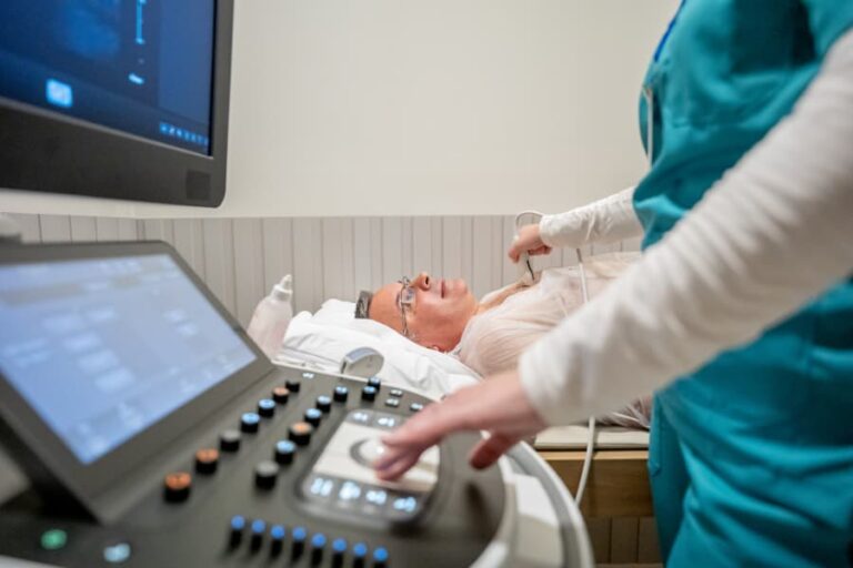 Patient receiving echocardiogram at medical clinical office with tech operating sonography machine